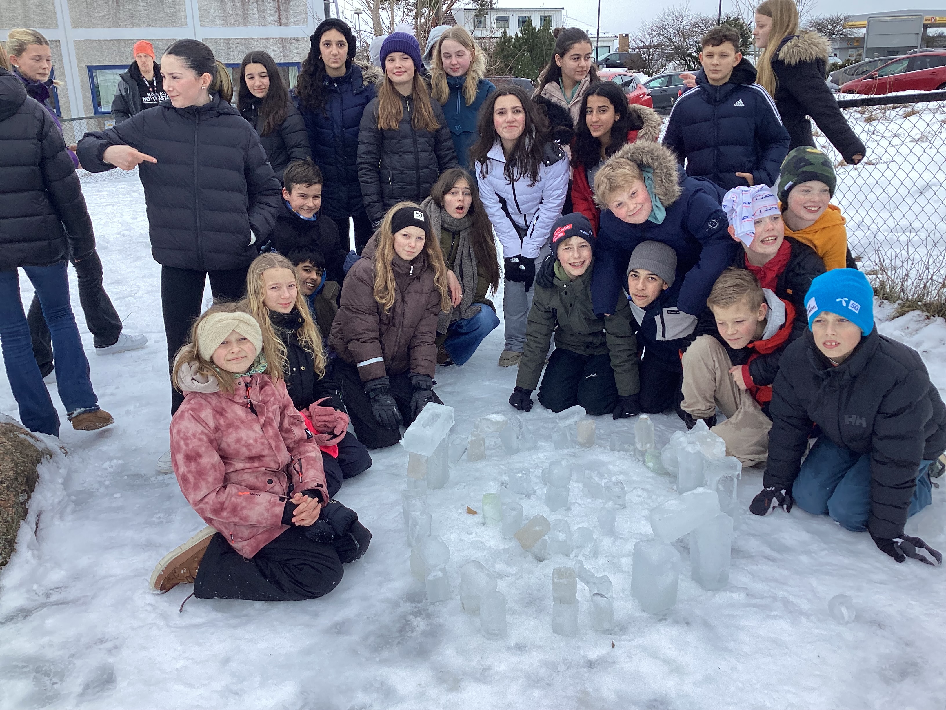 elever foran modell av Stonhenge laget av isblokker